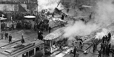 Blick auf die Straßenbahn und im Hintergrund das Flugzeugwrack und viele hundert Schaulustige, die sich nach dem Absturz schnell eingefunden haben. | Quelle: Archiv BFM